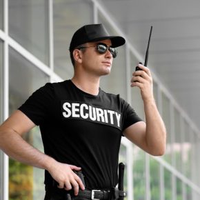 Male security guard with portable radio outdoors