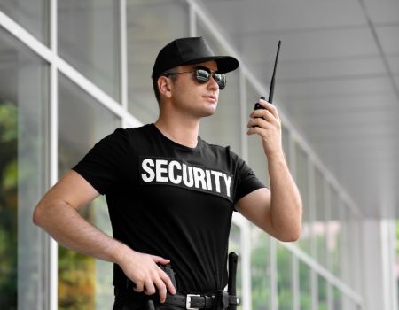 Male security guard with portable radio outdoors